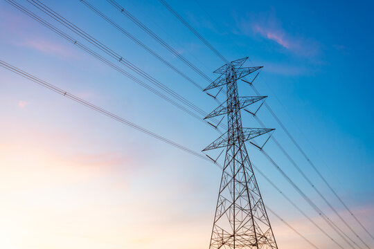 high-voltage power lines, high voltage electric transmission tower for producing electricity at high voltage electricity poles at the sunset. - Powered by Adobe