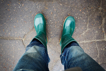 Rainy look. Rainy spring autumn weather. Clothes for the rain. Green rubber boots and jeans.