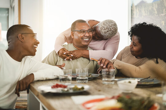 Happy black family eating lunch at home - Main focus on father face