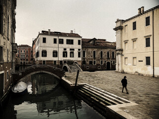 One unrecognizable people wearing a mask walking in a square in Venice, italy, during crisis COVID-19