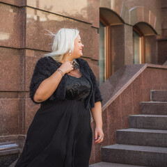 Woman of plus size, American or European appearance walks at the city enjoying life. A young lady...