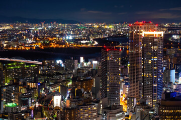 Japan. Night panorama of Osaka. Evening Osaka aerial view. Lights of the night city in Japan. Construction of overpass in Japan. River in the middle of the city. Traveling in Japan. Tour to Osaka.