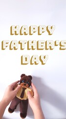 Happy Father's Day greeting card. Plush crochet teddy bear in a suit.