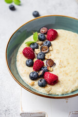 oatmeal with berries in bowl on white background