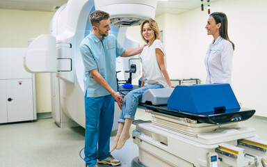 Cancer treatment in a modern medical private clinic or hospital with a linear accelerator. Professional doctors team working while the woman is undergoing radiation therapy for cancer