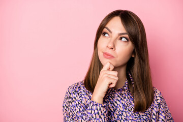 Photo portrait of thoughtful woman looking at blank space isolated on pastel pink colored background