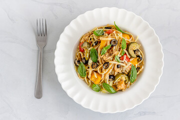 Summer Pasta with Bell Pepper, Zucchini, Olive and Chicken in a Bowl Top Down Photo