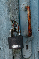 A rusty lock weighs on the door