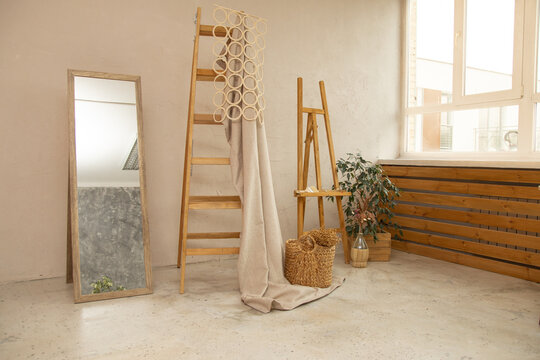 Natural studio or apartment decor, wooden staircase, mirror, concrete floor and wall, malbert and plant