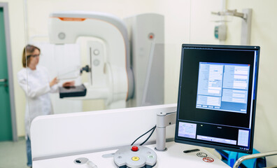 Cute professional woman doctor is working with modern Mammography X-Ray System Machine in a hospital or private clinic. Cancer and disease female treatment concept