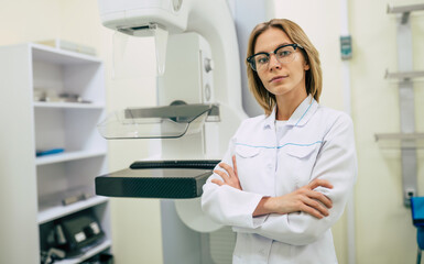Obraz premium Cute professional woman doctor is working with modern Mammography X-Ray System Machine in a hospital or private clinic. Cancer and disease female treatment concept