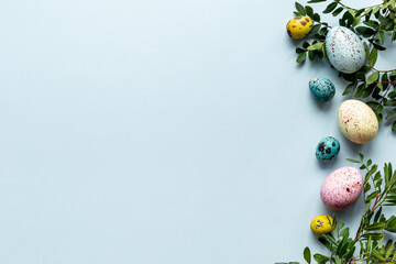 Easter decoration concept with eggs with spring branches and green leaves. Top view
