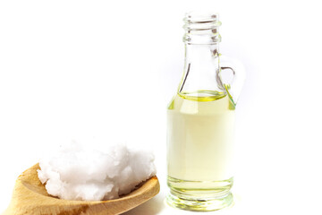 Unrefined coconut oil on a white background with wooden spoon