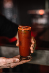 Bloody Maria cocktail decorated with salt, slice of lime and olives garnish.