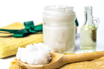 Unrefined coconut oil on a white background with wooden spoon