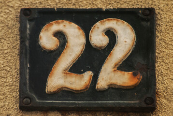 Old retro weathered cast iron plate with number 22 closeup