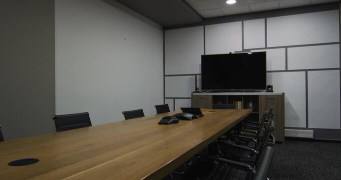 General view of empty conference room with television monitor, table and chairs in office