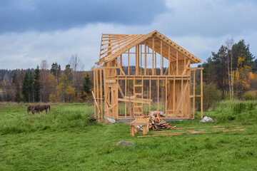 Frame of a standing cottage on the background of an autumn landscape. Wooden construction of a...