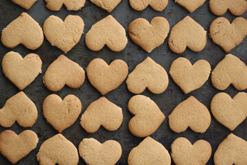 gingerbread cookies heart shaped on dark oven-tray background, Love, family, valentines or wedding day concept. Top view, horizontal