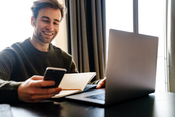 Mid aged man working on laptop computer from home