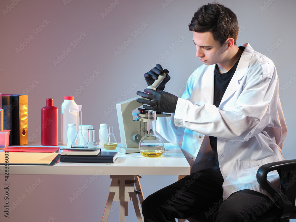 Poster a laboratory assistant examines samples of goods under a microscope. product quality control. a male
