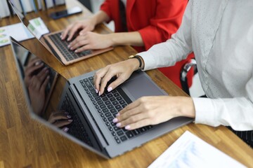 Obraz na płótnie Canvas Women typing on laptop keyboard in office closeup