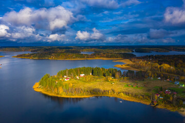 Karelia. Russian landscape from a drone. Lake Ladoga. Panorama of the lake and Islands from a height. The houses on the lake shore are illuminated by the sun. Autumn landscape of the lake district.