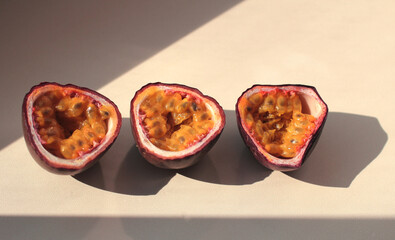 passion fruit cut into halves with a shadow on a lilac background