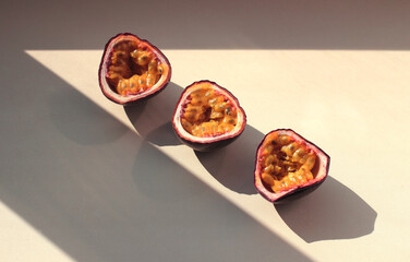 passion fruit cut into halves with a shadow on a lilac background
