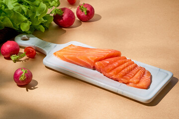 Colorful raw salmon salad with green fresh vegetable decoration