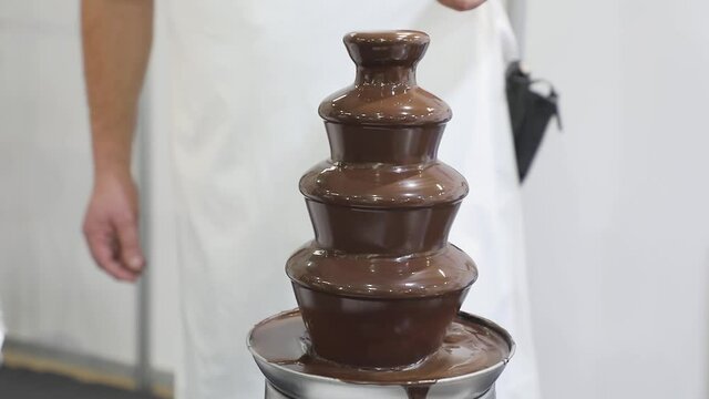 Dipping Skewer Sticks in Chocolate Fondue Fountain Tower