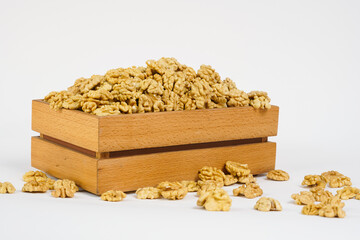   Peeled walnuts on white background. Nuts in  wooden box. Copy space. Healthy food concept.