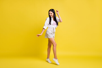 Full size photo of young beautiful smiling positive good mood girl dancing enjoying weekend isolated on yellow color background