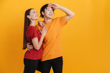 Young multiracial couple smiling and hugging while looking upward