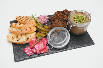 Appetizers with differents antipasti, charcuterie, snacks and red wine on white background. Sausage, ham, tapas, olives and crackers for buffet party. Top view, flat lay