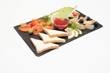 Bread with caviar and salted fish served on black dish