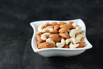 Cashew nut and almonds or badam dry fruits and nuts on white background layout Kerala India. Protein fiber rich food snack diet mixed nuts layout seeds, food for muscle body building.