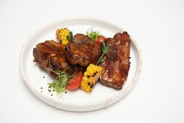 Delicious grilled pork ribs in BBQ sauce with herbs, isolated on white background