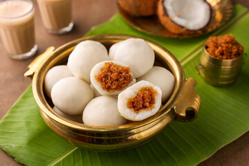 Kozhukatta Pidi in golden bowl Indian milk tea Kerala tea time snack steamed food sweet modak rice dumpling Ganesh Festival India sweet food stuffed grated coconut jaggery, christian food Palm sunday