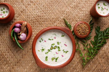 Fototapeta na wymiar Spiced buttermilk , chaas , chaach , moru , sambharam , curd, lassi , yogurt, cool refreshing drink for hot summer in a clay pot, Kerala, India. Flavored Indian buttermilk.