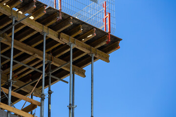 Scaffolding on the concrete walls of a newly constructed public utility building. Grodzisk Mazowiecki, Poland. Photo taken on a sunny day.