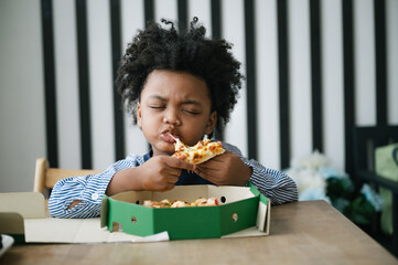 Happy black people African American child eat pizza on table