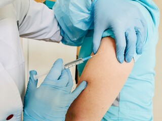 Close-up of a nurse giving an injection with a coronavirus or flu vaccine during a coronavirus outbreak.