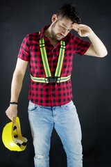Tired Construction Worker  in a dusty environment.Construction worker with yellow crash helmet....