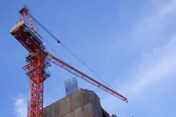 Cranes steel structure high-rise, Construction site, On backdrop of blue sky clear and morning sunrise with copy space, Industrial machinery, Mechanical and Engineering equipment outdoor workplace.