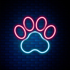 Glowing neon line Paw print icon isolated on brick wall background. Dog or cat paw print. Animal track. Colorful outline concept. Vector