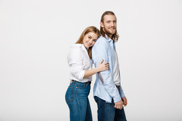 Portrait of cheerful young couple standing and hugging each other on isolated white background