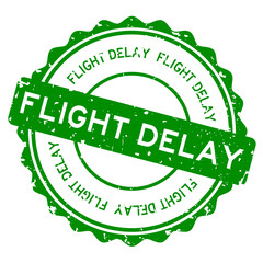 Grunge green flight delay word round rubber seal stamp on white background