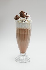 Tasty milk shake with chocolate topping on white background