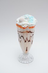 Tasty milk shake with chocolate topping on white background
